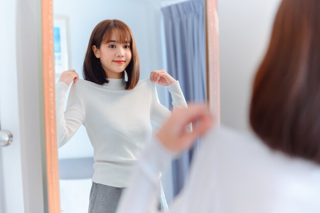 Photo asian woman dress-up at home. lifestyle in the bedroom. social distancing and self-quarantine.