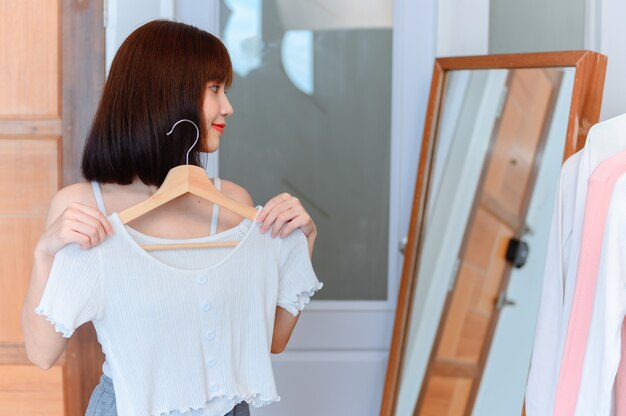 Photo asian woman dress-up at home. lifestyle in the bedroom. social distancing and self-quarantine.