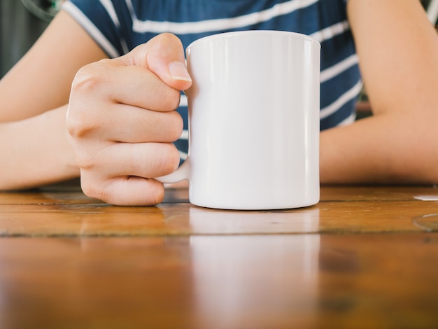 アジアの女性はドリンクを飲み、コーヒー・カフェでリラックスします。