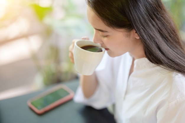 Asian Woman drinking coffee at the cafe