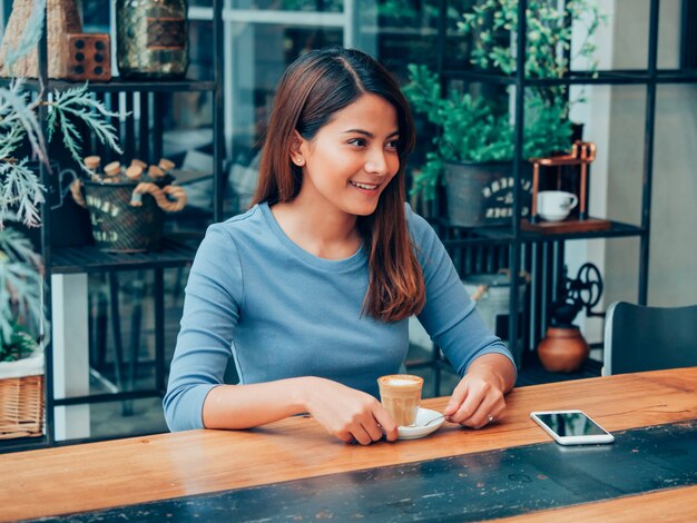 Азиатская женщина, пить кофе в кафе кафе