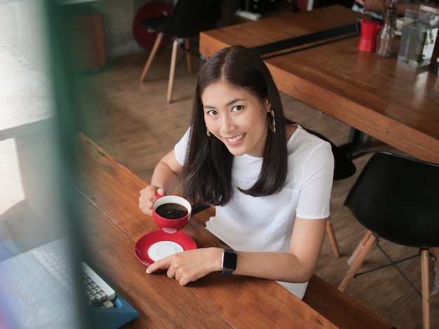 Asian woman drinking coffee in  coffee shop cafe  