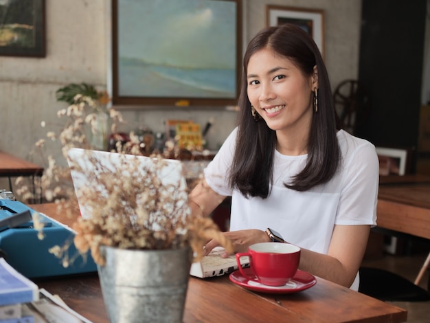 커피 숍 카페에서 커피를 마시는 아시아 여자