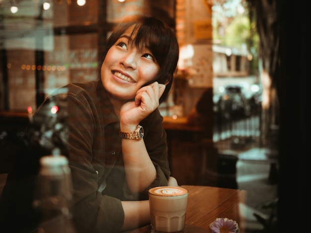 Asian woman drinking coffee in  coffee shop cafe  