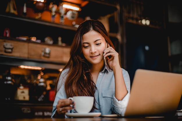 Asian woman drinking coffee latte in cafe vintage color tone