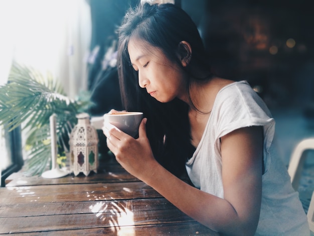 朝のコーヒーを飲むアジアの女性。