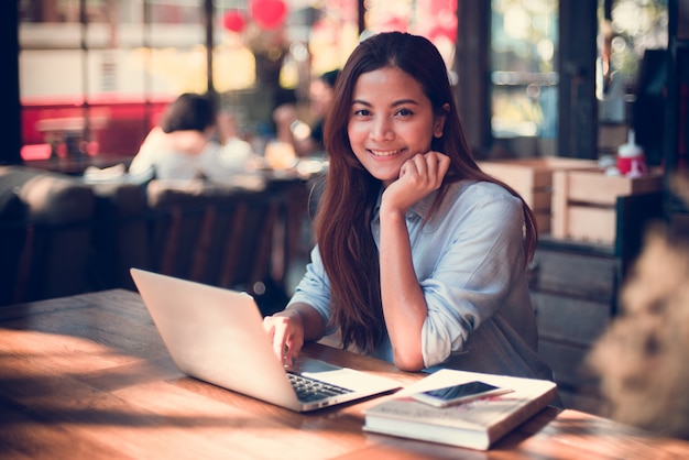 Asian woman drinking coffee in vintage color tone