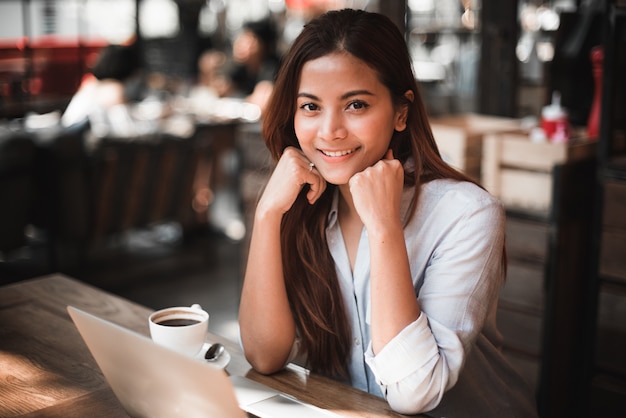 Asian woman drinking coffee in vintage color tone