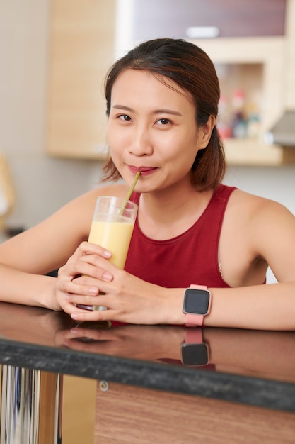 Asian woman drinking tasty fruit cocktail