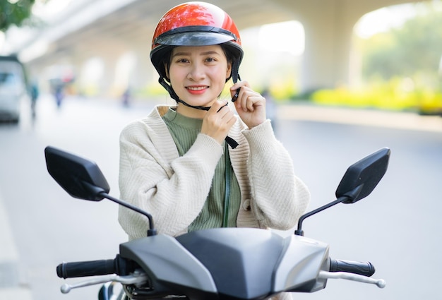 Asian woman driving a motorbike on her way to work