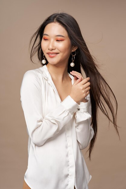 Asian woman in earrings makeup white shirt