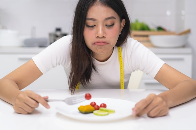 Foto la donna asiatica mangia disordine durante la dieta.