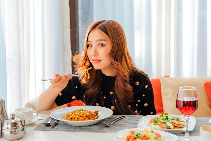 Photo 焼きそばを入れた料理を食べるアジアの女性