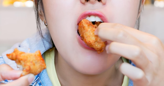 아시아 여성이 먹고 있습니다.
