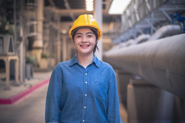 Asian woman engineer standing confident concept Asian woman are engineer factory inspecting machine in factory with computer Asian woman engineer working in factory Asia woman confident