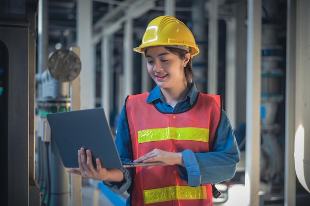 Asian woman Engineer using computer working in factory