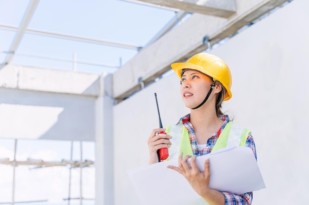 Asian woman engineer worker work in construction site Smart builder architect female in safety suite working