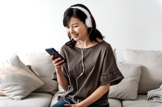 Photo asian woman enjoying music at home