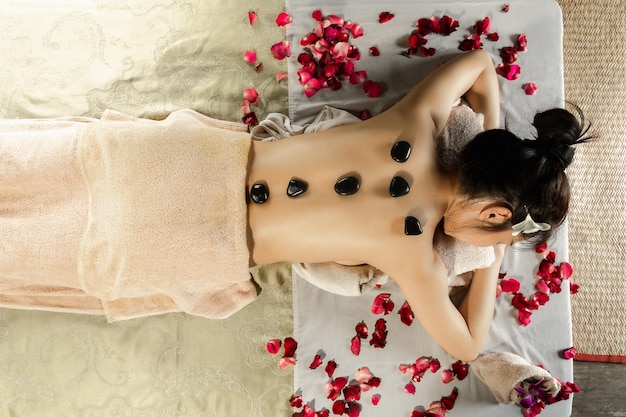 Азиатская женщина наслаждается соляным скраб-массажем в спа-салоне Здравоохранение спа и тайский массаж