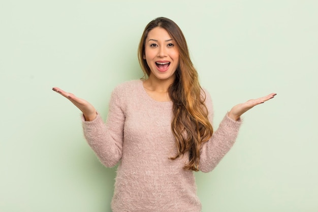 Asian woman feeling happy excited surprised or shocked smiling and astonished at something unbelievable