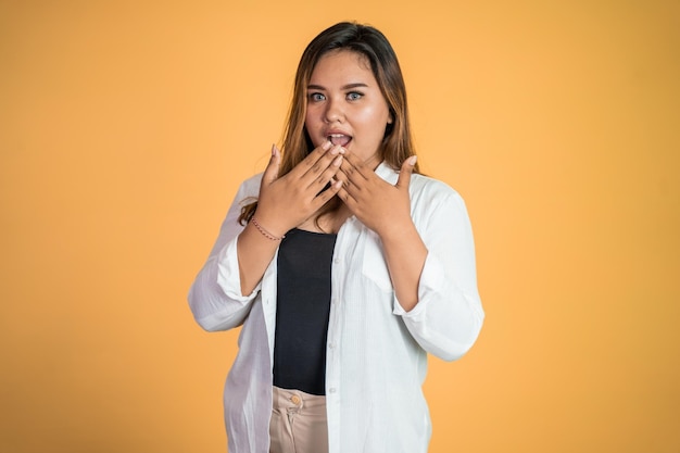 Asian woman feeling shocked and suprised over isolated background