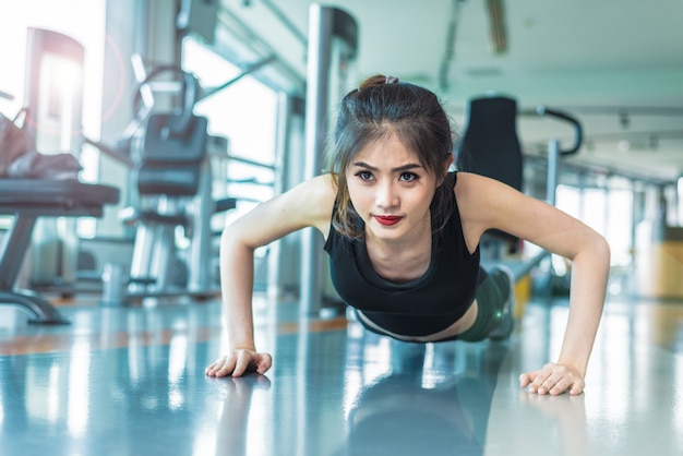 Азиатская женщина фитнес-девушка делает толкает вверх в фитнес-зал