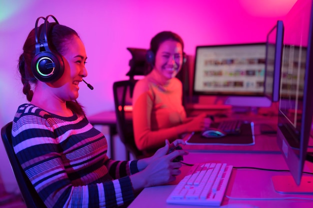 Asian woman gamer play online game with joystick and computer E sport team at game center