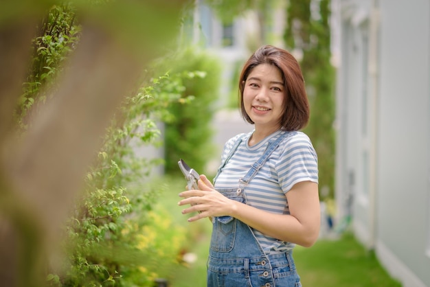 剪定はさみを持つアジアの女性の庭師の肖像画