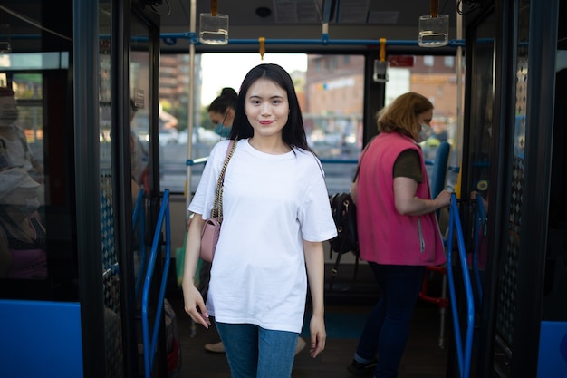 Asian Woman get out through doors after ride in public transport stop bus or tram