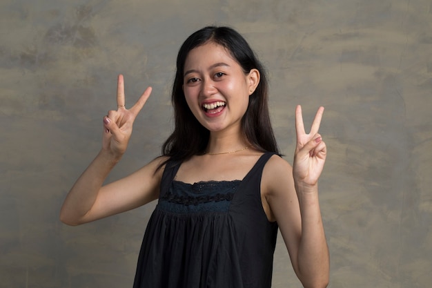 Asian woman giving peace victory, two sign gesture