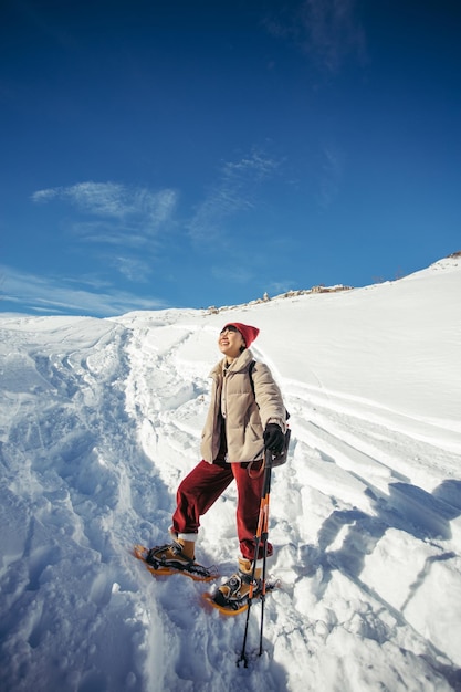 La donna asiatica va a sciare in montagna innevata