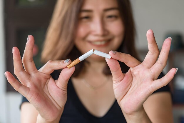 Foto donna asiatica che schiaccia la sigaretta a mano smettendo di fumare dal concetto di dipendenza nessun giorno di tabacco nessun concetto di fumo