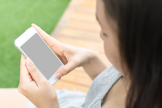 Asian woman hand holding mobile phone and blank copy space screen for your text