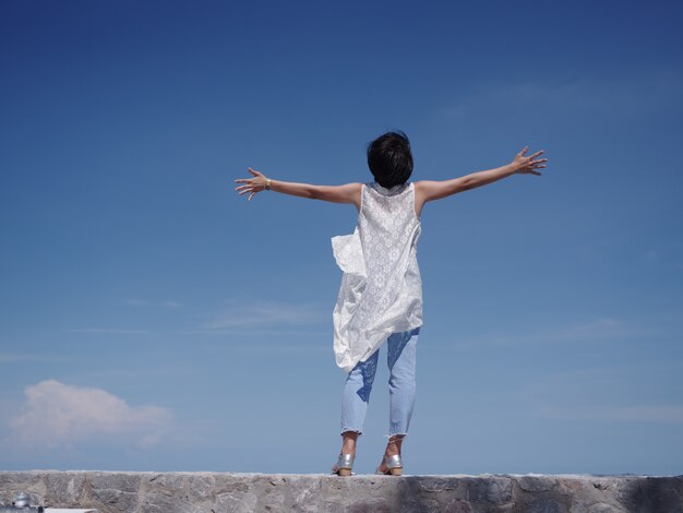 Photo asian woman happy and smile on the beach and blue sky 
