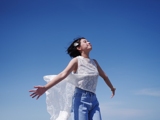 アジアの女性の幸せとビーチと青い空に笑顔