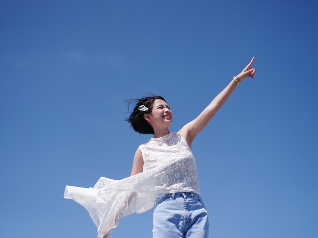 Photo asian woman happy and smile on the beach and blue sky 
