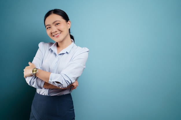 Foto donna asiatica felice sorpresa in posa sull'azzurro.