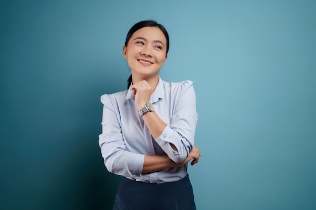 Asian woman happy surprised posing on blue.