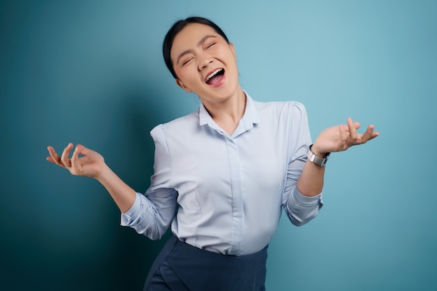 Asian woman happy surprised posing on blue.