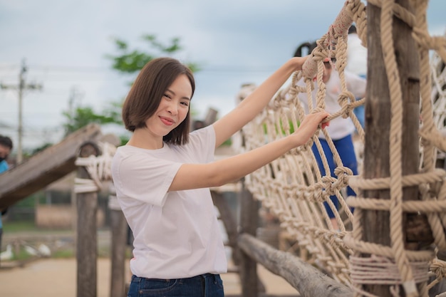 Fondo del campo da giuoco della scuola dell'insegnante felice della donna asiatica