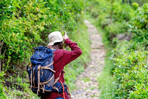 Asian woman in a hat and backpack walking