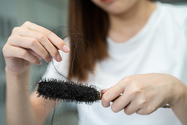 Asian woman have problem with long hair loss attach to comb brush