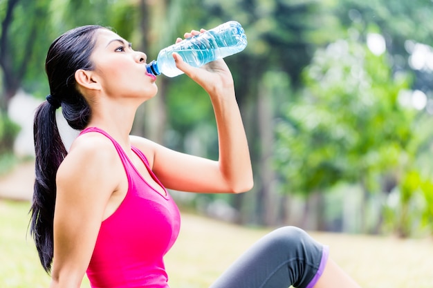 Asian woman having break from sport training