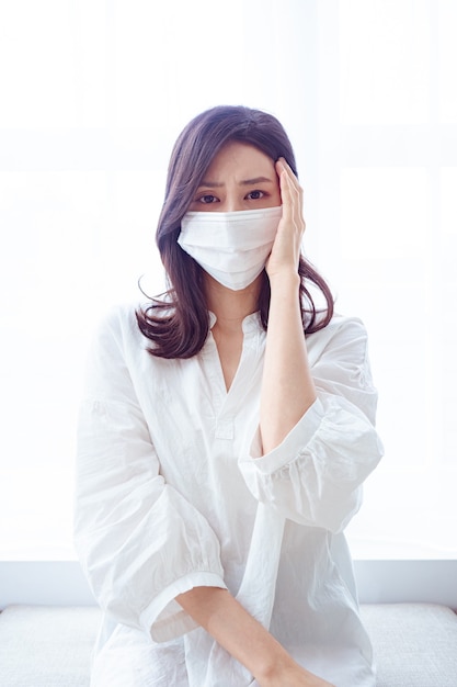 Asian woman having headache on white background