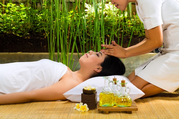 Asian woman having a massage in tropical setting