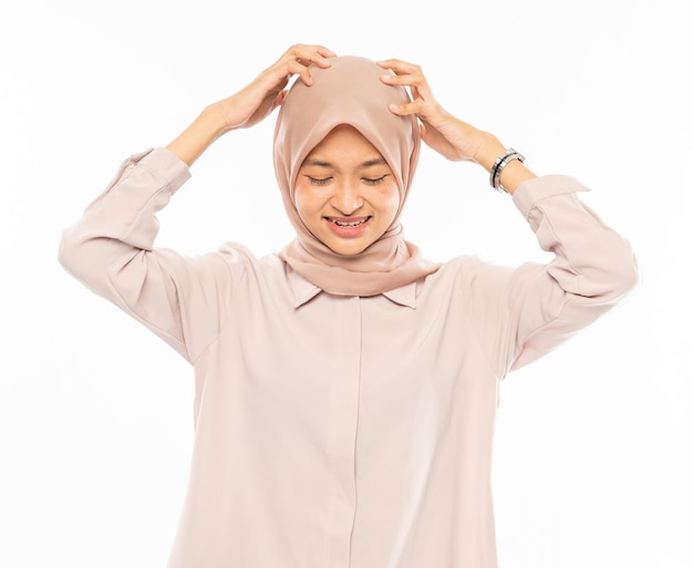 Asian woman in hijab holding and scratch her head