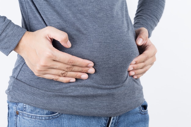 Asian woman holding belly fat on white background