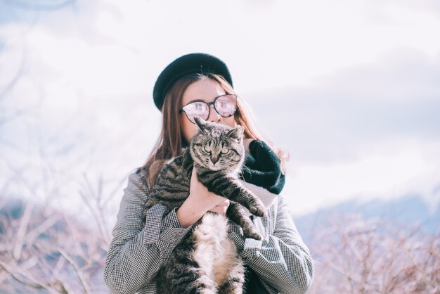 Asian woman holding a cat outdoors in japan winter