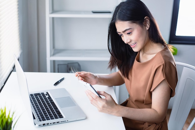 Asian woman holding credit card and using laptop online shopping concept