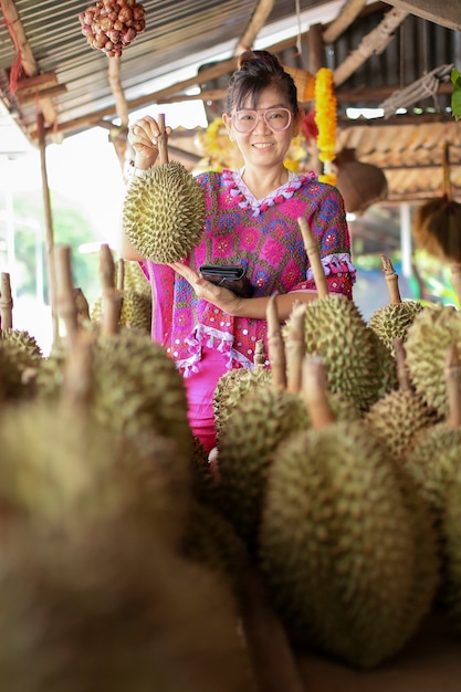 ドリアンの果物と歯のある笑顔を保つアジアの女性